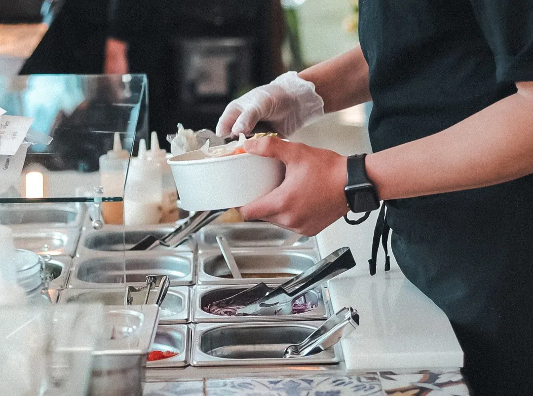 A poké bowl being assembled at the Maw Poké counter